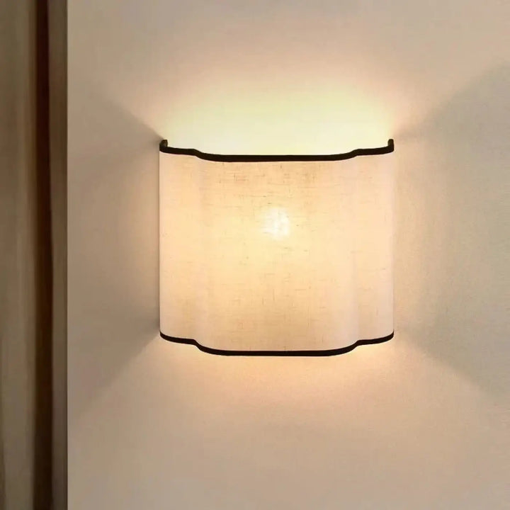 Applique murale susso avec lumière douce, abat-jour en lin courbé et bordure noire pour décoration intérieure chaleureuse