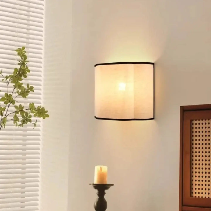Applique murale carrée avec abat-jour en tissu beige et bordure noire pour une décoration intérieure à lumière douce