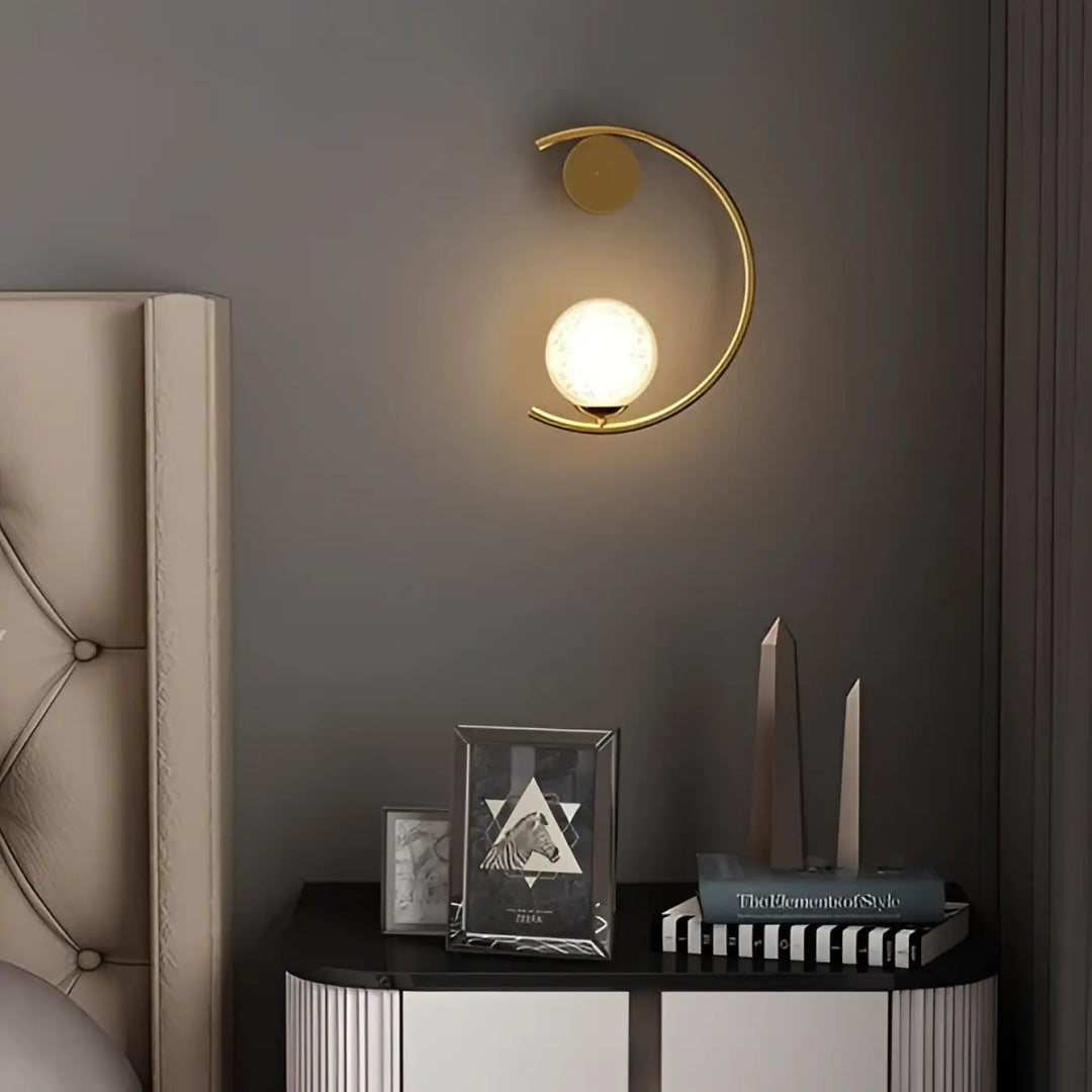 Applique murale lune en métal doré en forme de croissant avec globe en verre dépoli offrant une lumière douce et capacité à s’adapter