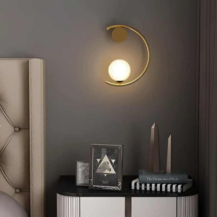 Applique murale lune en métal doré en forme de croissant avec globe en verre dépoli offrant une lumière douce et capacité à s’adapter