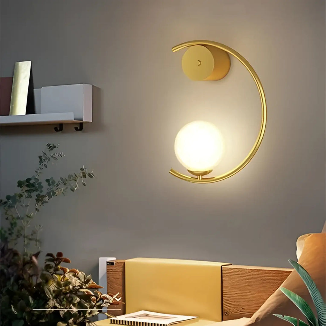 L’applique murale lune en métal doré avec globe en verre dépoli offrant une lumière douce et capacité à s’adapter
