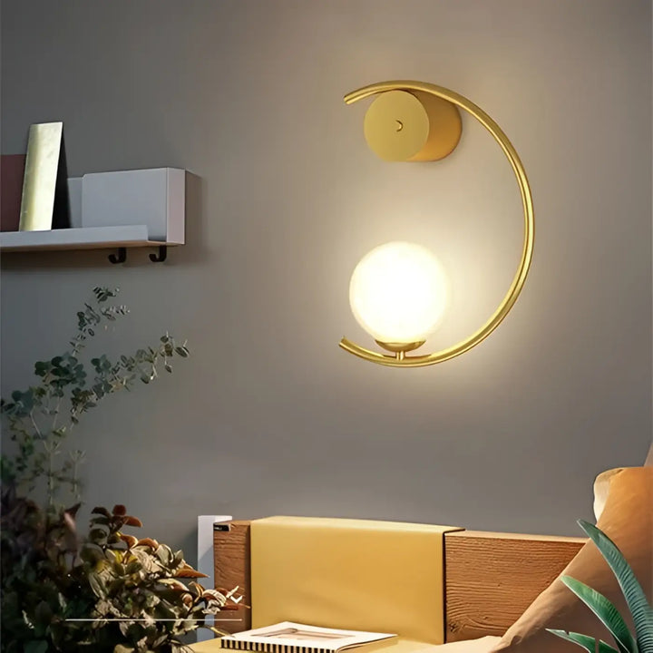 L’applique murale lune en métal doré avec globe en verre dépoli offrant une lumière douce et capacité à s’adapter