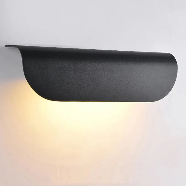 Applique murale minimale nox en finition mate noire avec design courbé diffusant une lumière ambiante chaleureuse