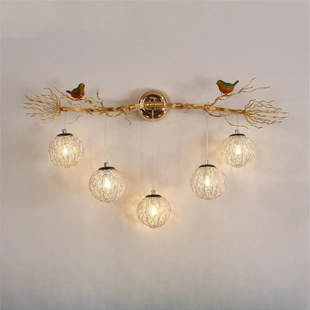 Applique murale moderne sylvana en métal doré avec design arbre et oiseaux verts et orange tenant des globes lumineux