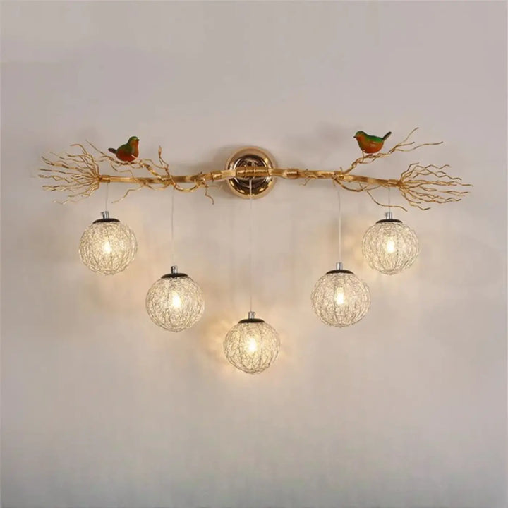 Applique murale moderne sylvana en métal doré avec design arbre et oiseaux verts et orange tenant des globes lumineux