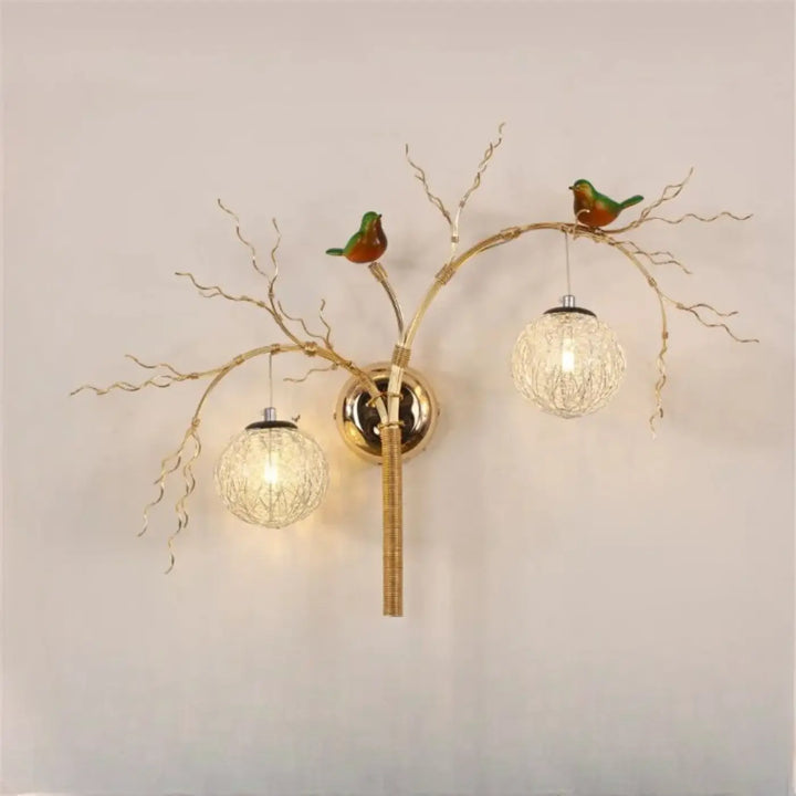 Applique murale sylvana en métal doré avec design branche orné d oiseaux verts et globes en verre tressé moderne