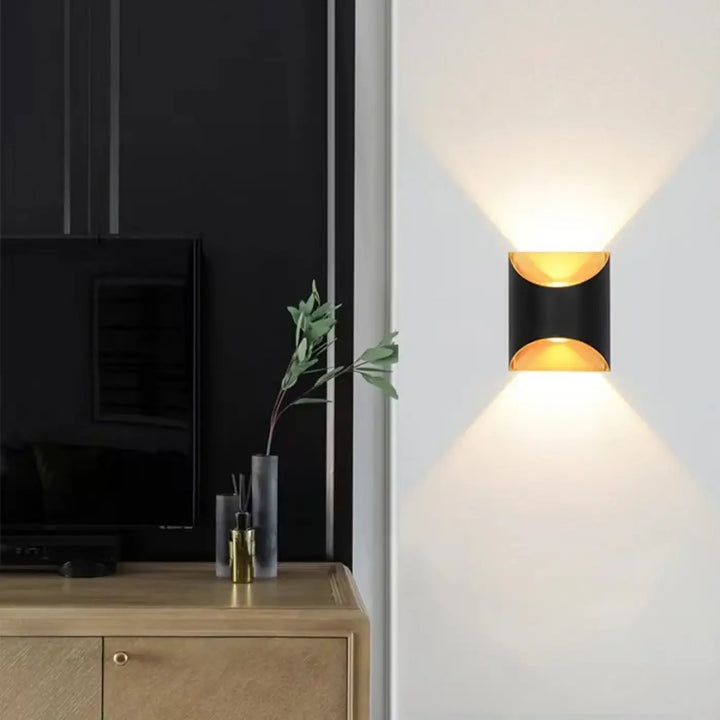 Applique murale moderne noir et or en métal avec design minimaliste diffusant une lumière chaude murale moderne
