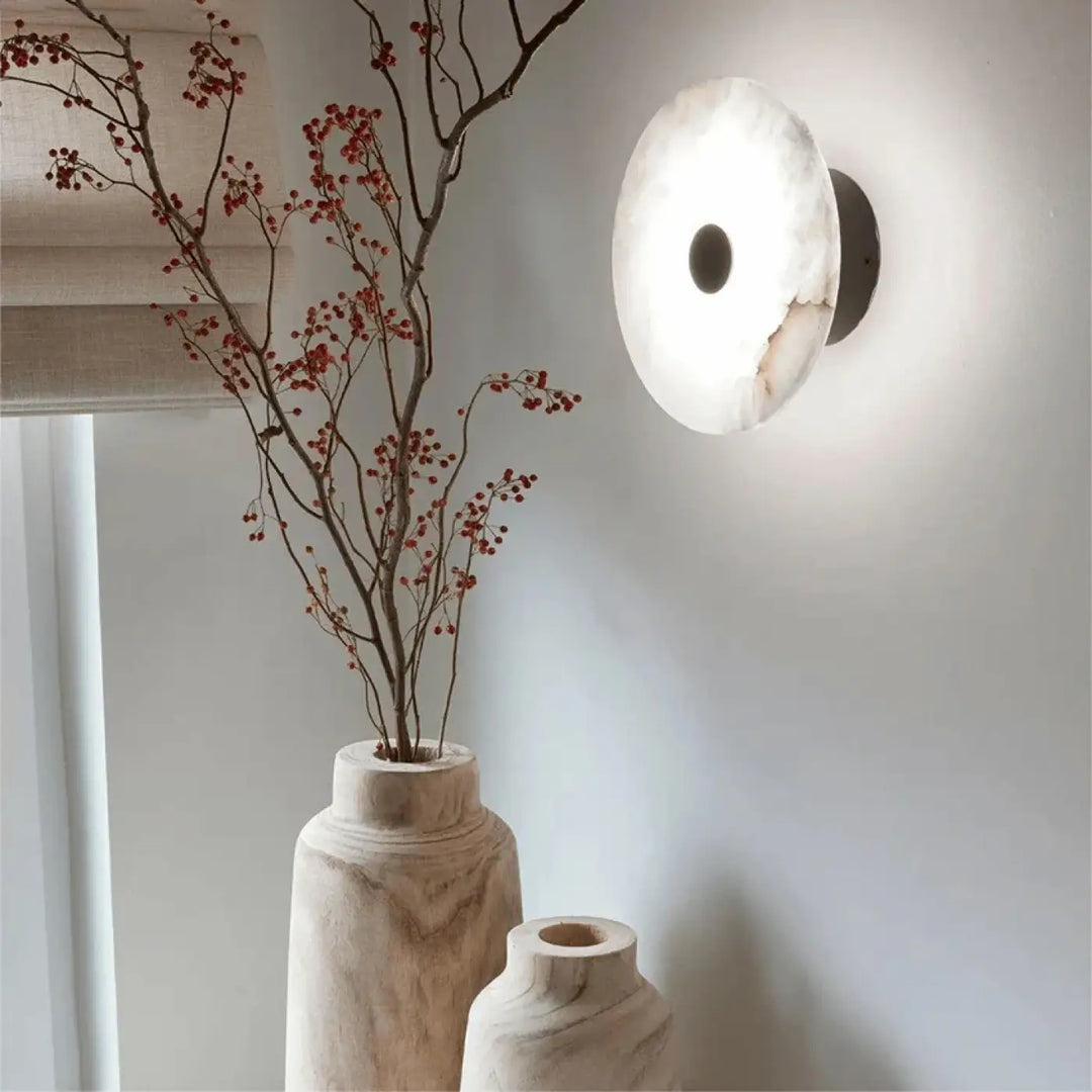 Applique murale moderne en marbre beige avec un support noir et un trou central sombre design moonya