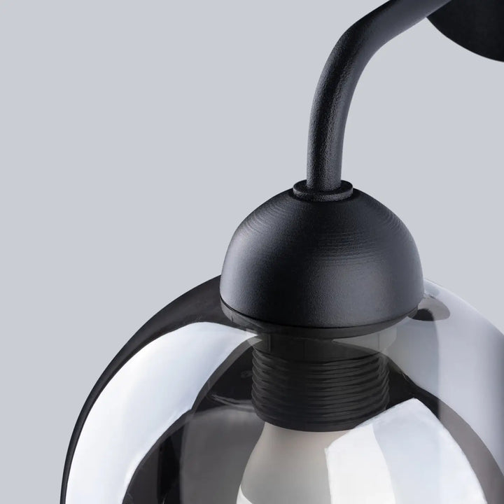 Applique murale alino 1 noir en métal mat avec bras incurvé et globe en verre teinté de la collection alino