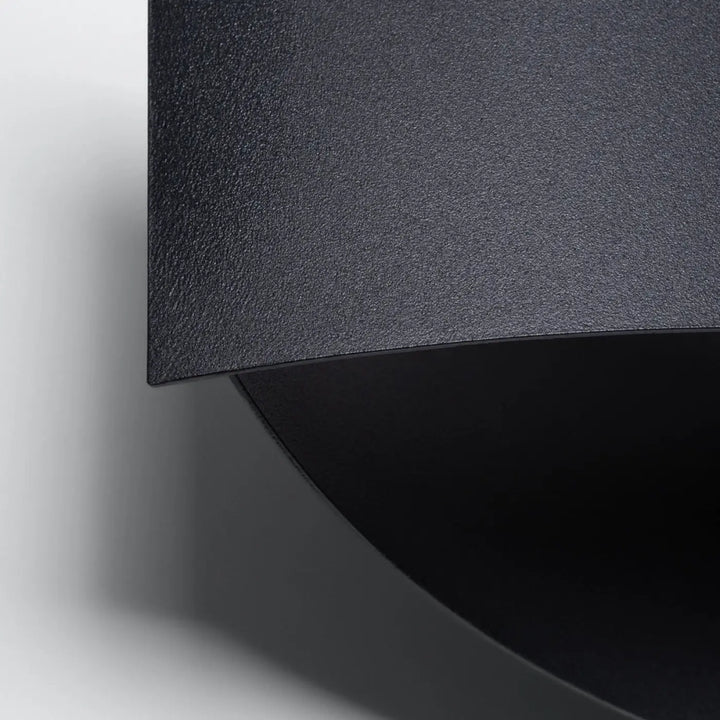L’applique toni noir finition matte en métal avec design courbé moderne et ornement subtil pour couleurs classiques