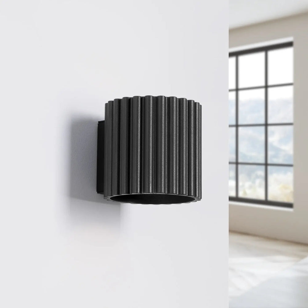 Applique murale aura noir en forme unique inspirée avec cylindre noir rainuré et finition mate pour mur intérieur