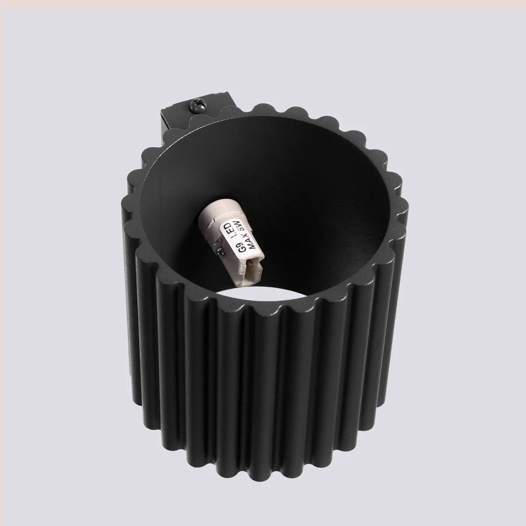 Applique murale aura noir noire avec forme unique inspirée et design en cylindre led à surface striée avec support intégré