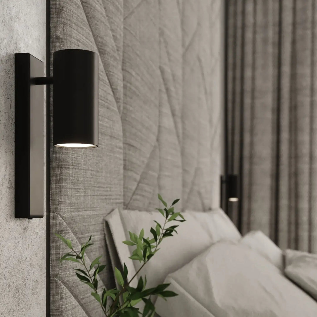 Applique murale utti noire cylindrique avec finition mate sur plaque rectangulaire pour une forme discrète élégante
