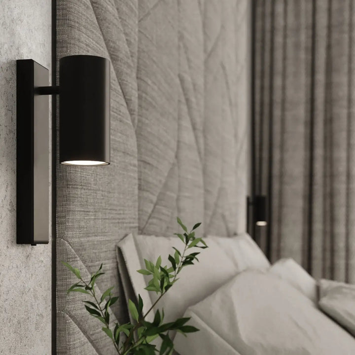 Applique murale utti noire cylindrique avec finition mate sur plaque rectangulaire pour une forme discrète élégante