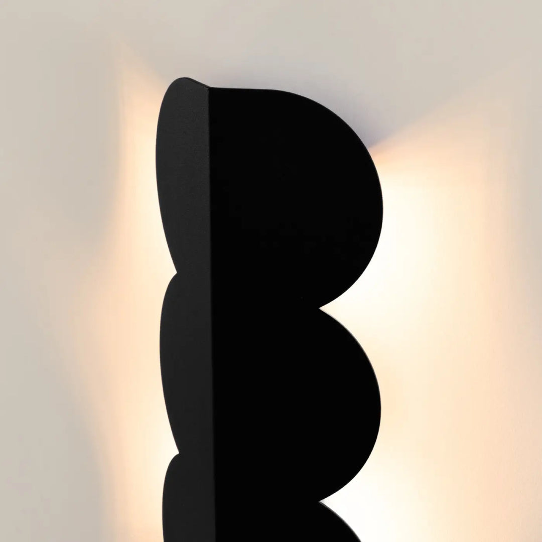 Applique murale biscuit noir compose d’une lampe suspendue avec une forme ondulée caractéristique et luminaires biscuit allient design moderne