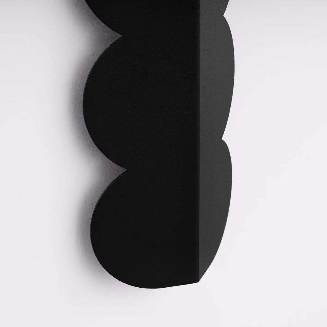 Applique murale biscuit noir avec forme ondulée caractéristique et design moderne compose d’une lampe suspendue