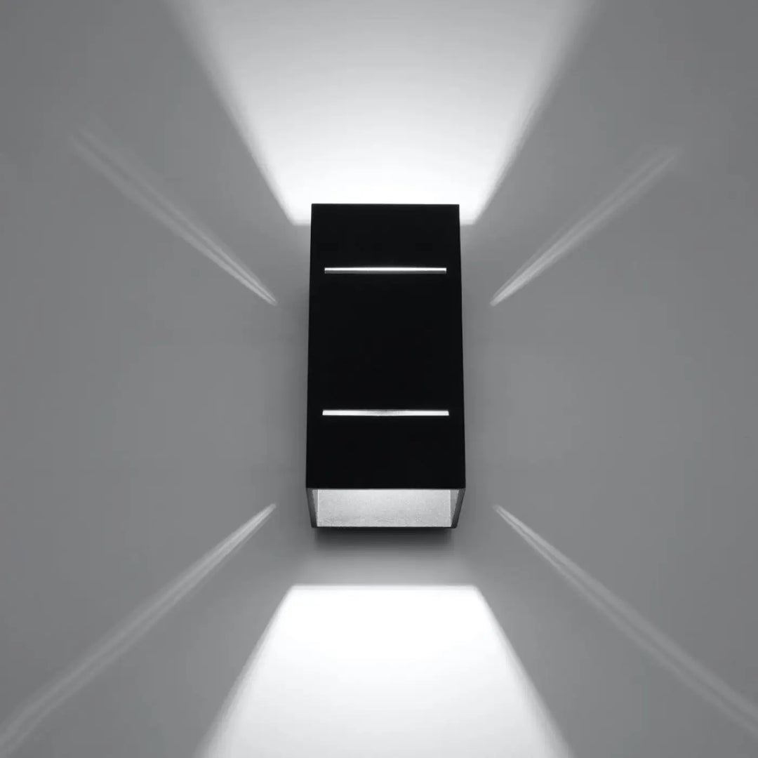 L’applique blocco noire avec diffuseur en verre dépoli et accents argentés pour un spectacle lumineux perforation linéaire