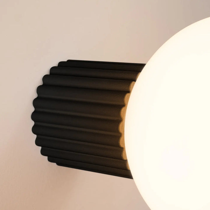 Applique murale halo noire avec finition mate et sphère laiteuse idéale comme lampe halo décorative pour bureau