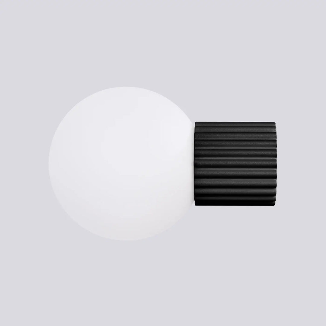 Applique murale halo noir avec base cylindrique nervurée et sphère laiteuse pour un bureau décorative elegante