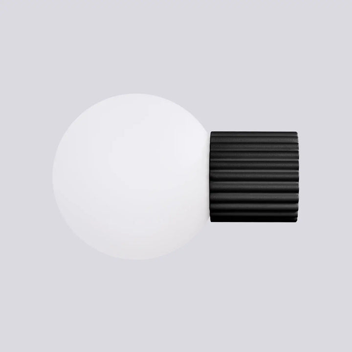 Applique murale halo noir avec base cylindrique nervurée et sphère laiteuse pour un bureau décorative elegante