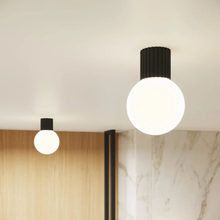 Applique murale halo noire avec socle cylindrique nervuré et sphère laiteuse pour bureau décorative