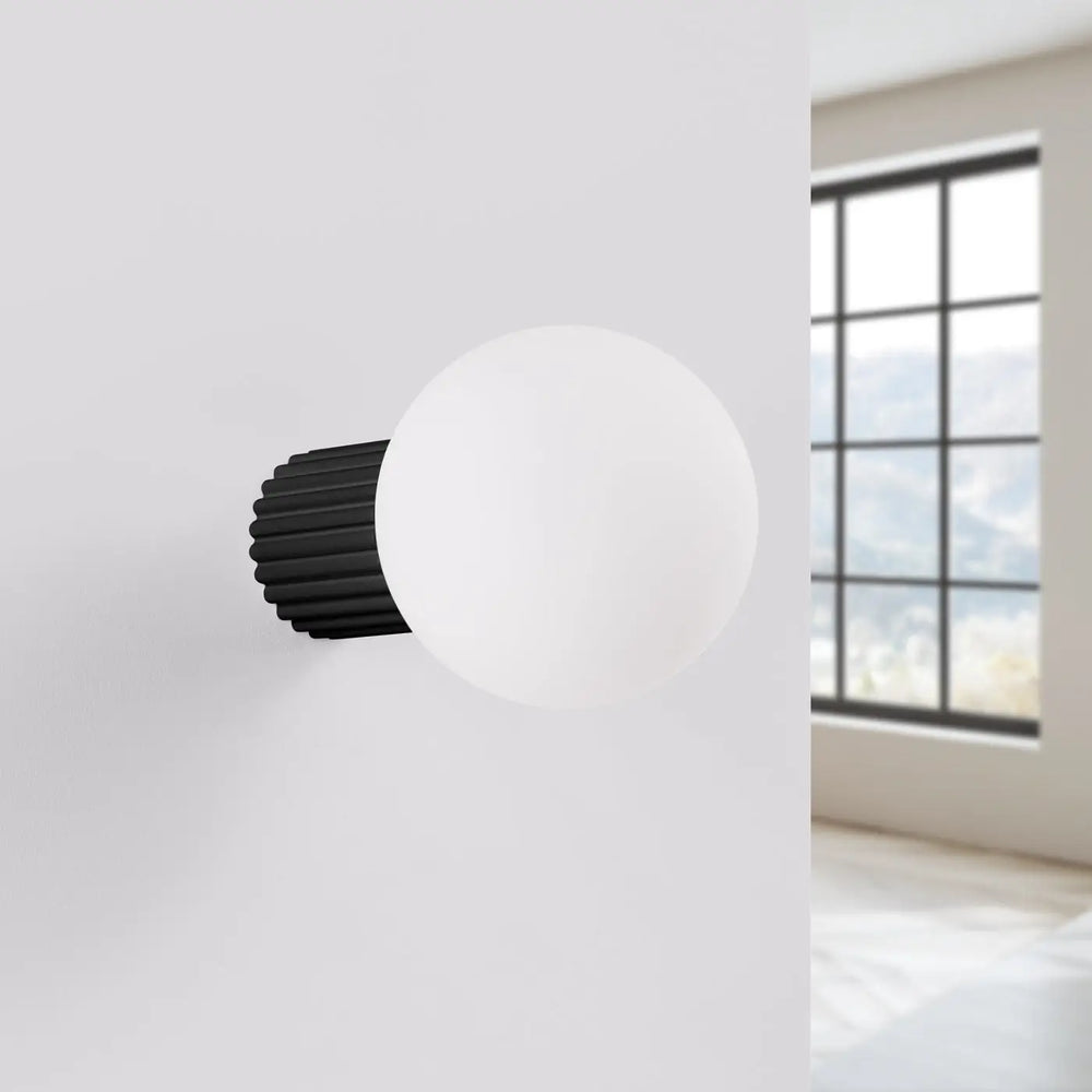 Applique murale lampe halo noire avec sphère laiteuse en verre dépoli et base métallique cannelée pour bureau décorative