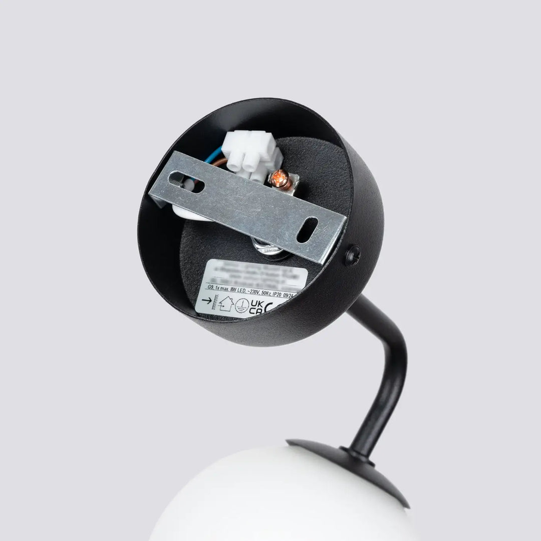 Applique murale lampe astral noir mat avec bras courbé et ampoule sphérique blanche édition minimaliste collection astral