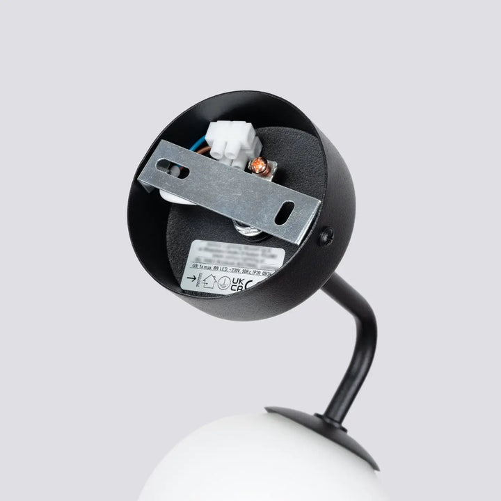 Applique murale lampe astral noir mat avec bras courbé et ampoule sphérique blanche édition minimaliste collection astral