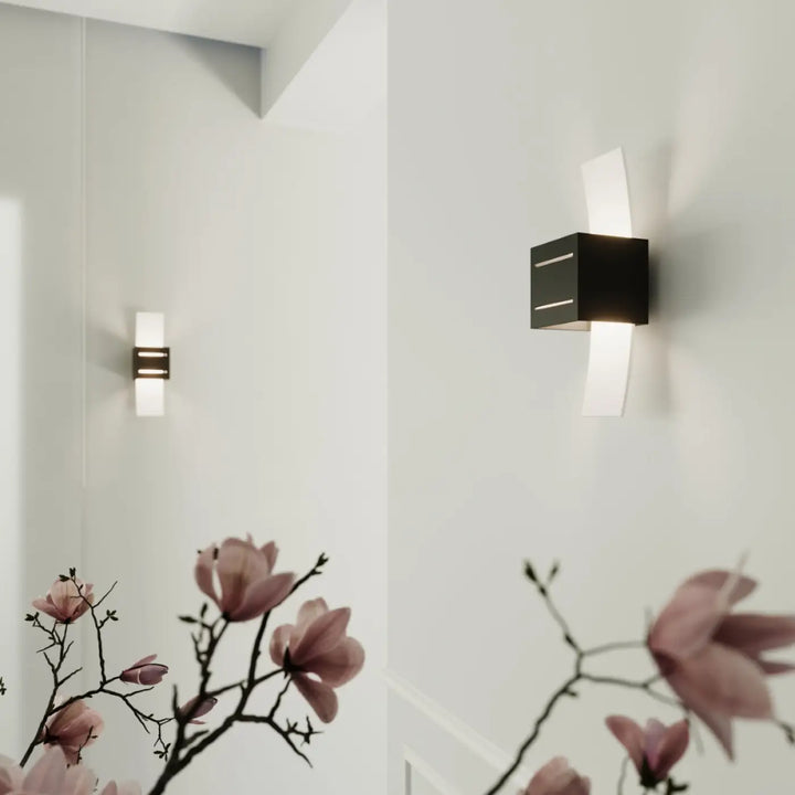 Applique murale loreto noire avec diffuseur blanc incurvé design moderne et perforation linéaire minimaliste
