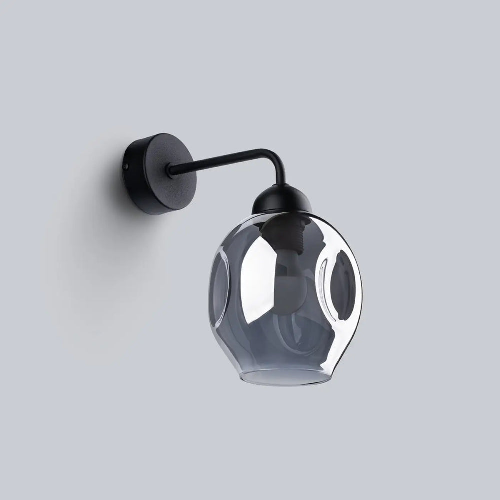 Une applique murale fillan noir avec un globe gris translucide à motifs découpés subtilement ressemble l’applique fillan