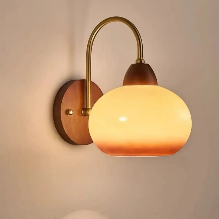 Applique murale arkenea finition dorée avec verre ovale chaud, bras en laiton et platine murale rétro chic en bois