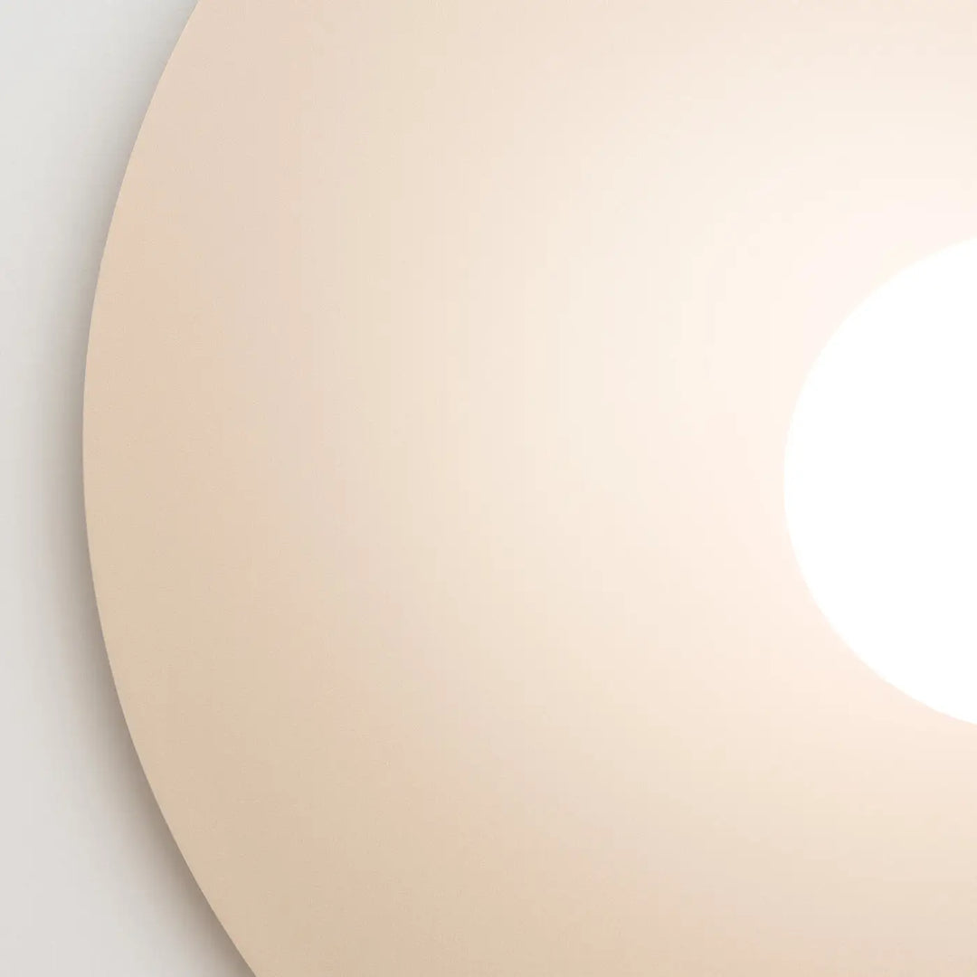 L’applique murale ake 50 beige avec disque métallique rond diffusant une lumière douce à sphère laiteuse créent ambiance