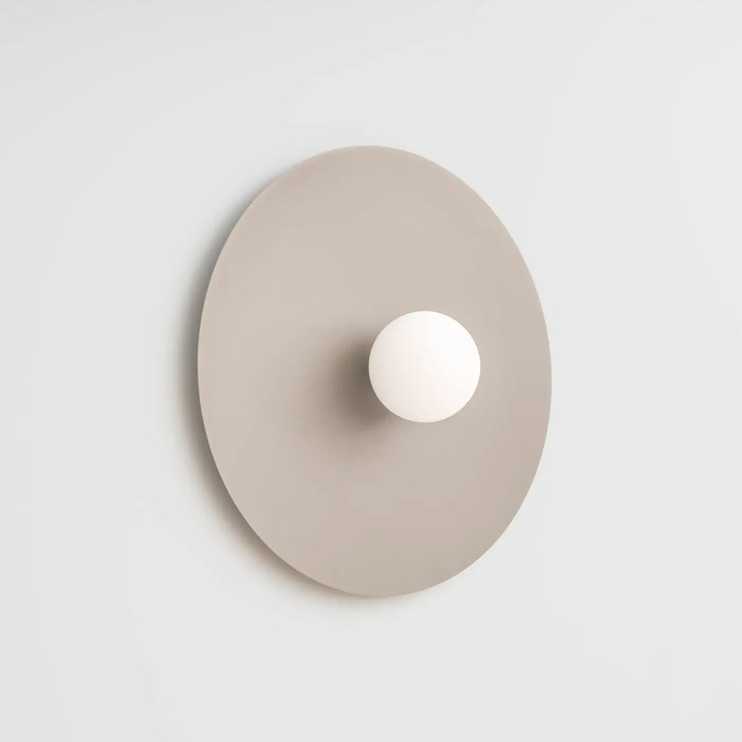 Applique murale ake 50 taupe avec disque métallique rond et sphère laiteuse créent une ambiance d inspiration rétro