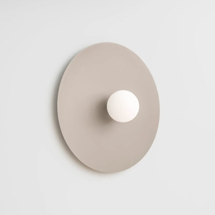 Applique murale ake 50 taupe avec disque métallique rond et sphère laiteuse créent une ambiance d inspiration rétro