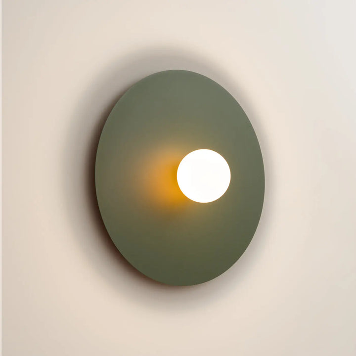 Applique murale ake 50 vert olive disque métallique rond avec sphère laiteuse créent une ambiance inspiration rétro