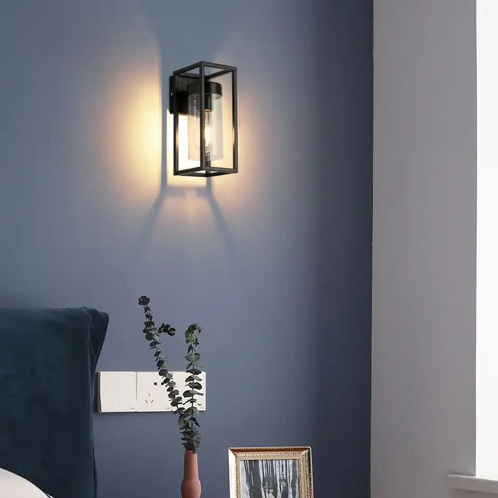 Applique murale orion en verre clair avec cadre noir illuminée dans un style industriel chic élégant