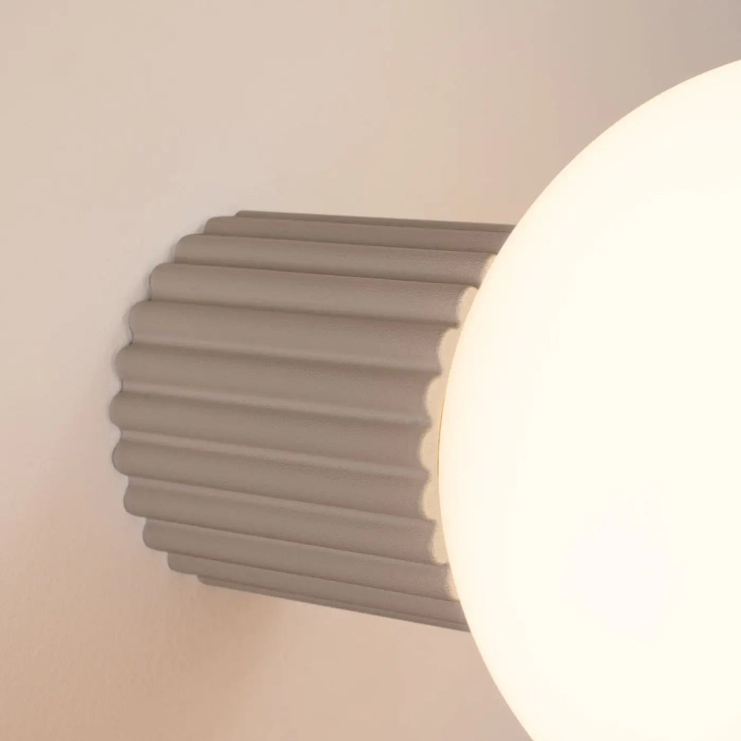Applique murale lampe halo taupe avec base cylindrique cannelée grise et ampoule sphérique blanche pour bureau décorative