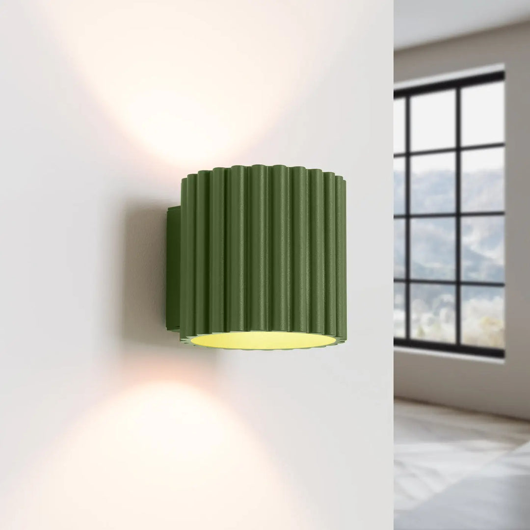 Applique murale aura vert olive cylindrique avec rainures verticales et lumière intérieure chaude forme unique inspirée