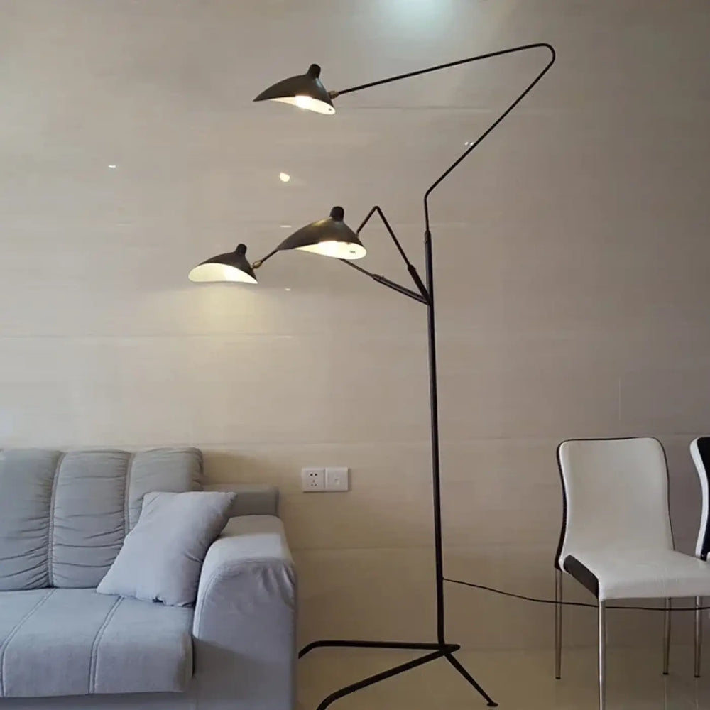 Lampadaire contemporain arbora en métal noir avec trois bras articulés et silhouette sculpturale diffusant une lumière chaude