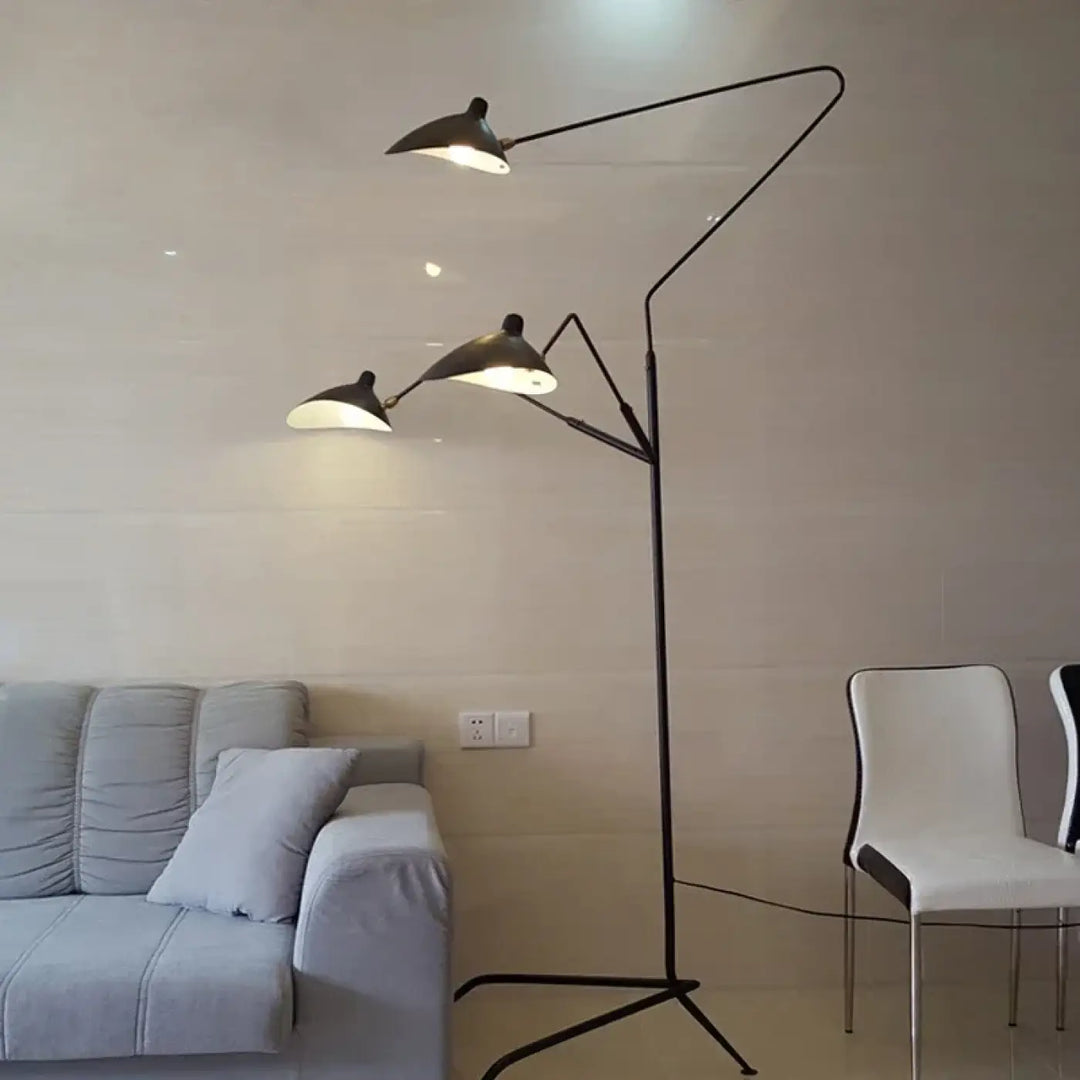 Lampadaire contemporain arbora en métal noir avec trois bras articulés et silhouette sculpturale diffusant une lumière chaude