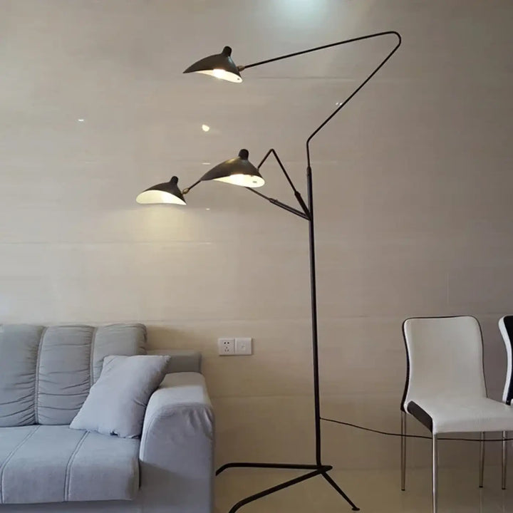 Lampadaire contemporain arbora en métal noir avec trois bras articulés et silhouette sculpturale diffusant une lumière chaude