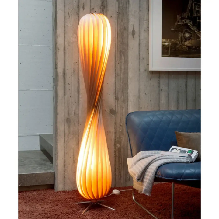 Lampadaire marron design sculptural avec une base métallique minimaliste et un abat-jour tordu orange lumineux