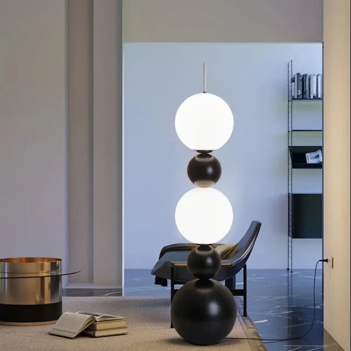 Lampadaire maitora minimaliste chic avec boules lumineuses empilées en noir brillant et blanc mat pour décoration intérieure