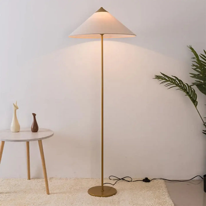 Lampadaire minimaliste rinessa finition dorée avec abat-jour conique en tissu crème pour une décoration intérieure chaleureuse