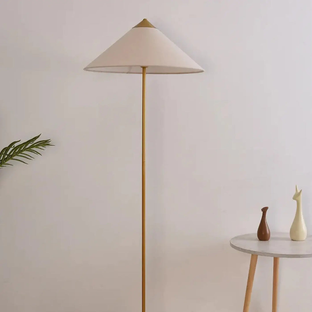 Lampadaire minimaliste rinessa avec pied en métal doré et abat-jour conique crème pour une décoration intérieure chaleureuse