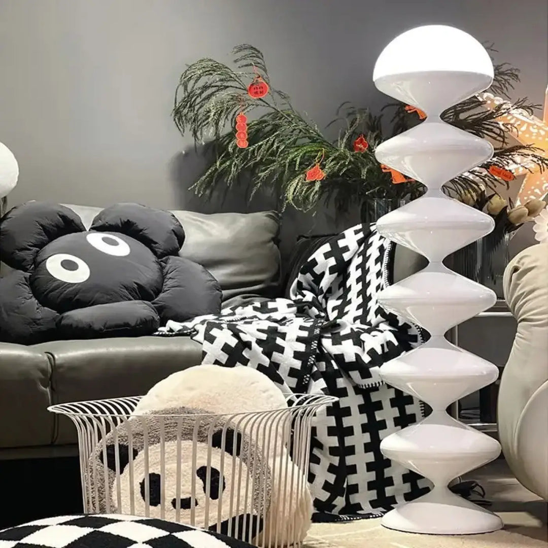 Lampadaire moderne blanc en matériau brillant avec segments sculpturaux en forme de disques torsadés pour éclairage élégant