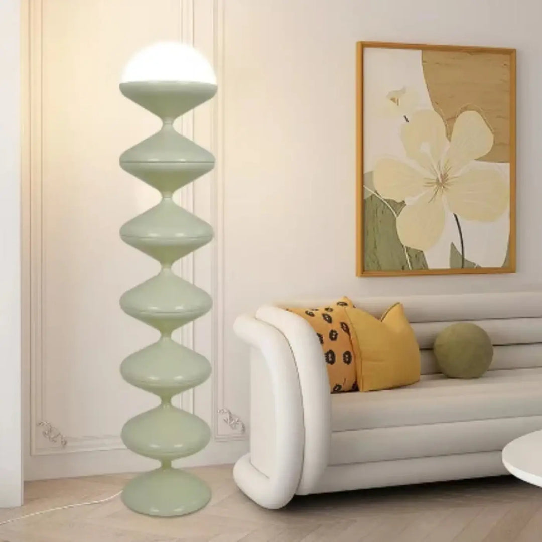Lampadaire moderne mousha avec design unique de disques vert clair empilés et éclairage élégant à globe blanc lumineux