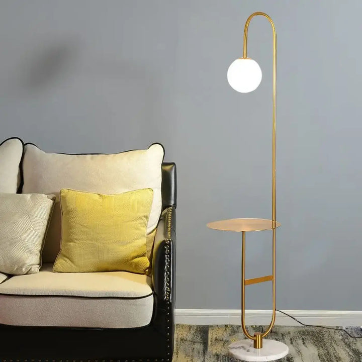 Lampadaire moderne gold avec abat-jour sphérique en verre blanc et base en marbre pour un éclairage raffiné