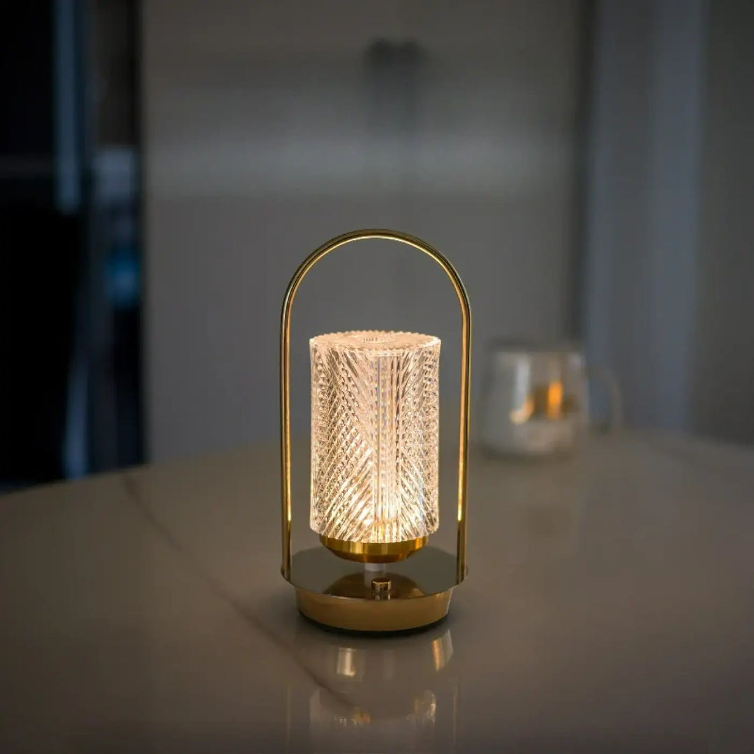 Lampe de chevet miu en métal doré avec verre translucide facetté et cadre arqué offrant un design élégant et une présence lumineuse