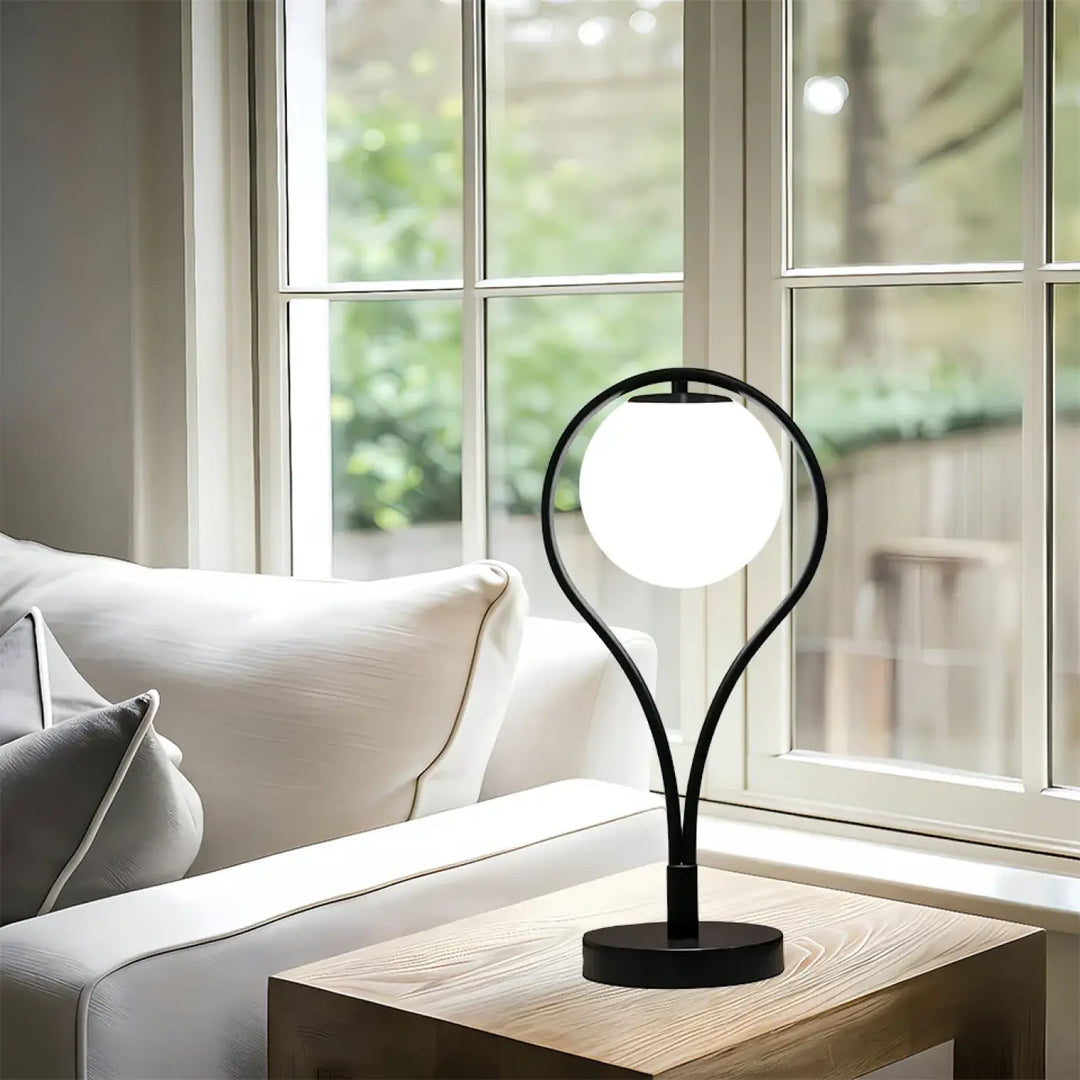 Lampe de table canila noire avec base courbée moderne et globe blanc pour un halo lumineux et un chevet design